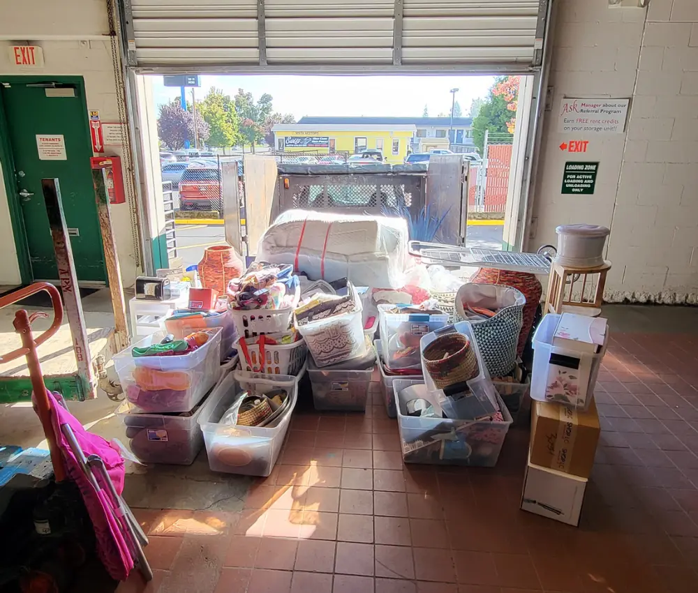 commercial cleanout of storage unit with staged housewares by door ready to be loaded and recycled