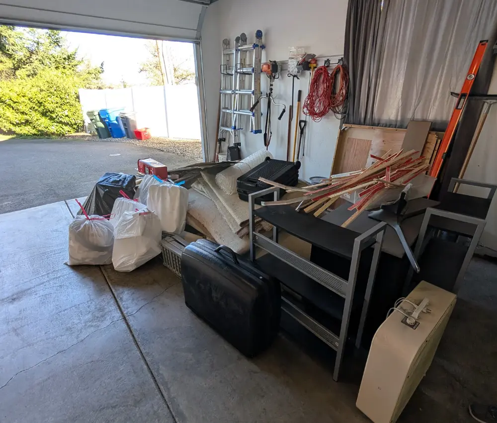 Garage filled with carpet and furniture before expert removal by patriot hauling and junk removal