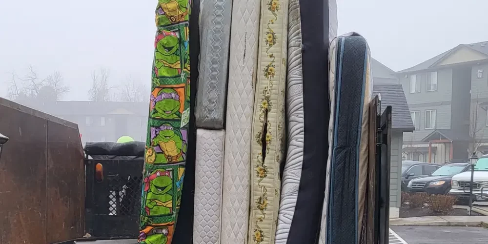 Junk truck filled with mattresses after expert furniture removal service provided by patriot hauling and junk removal LLC