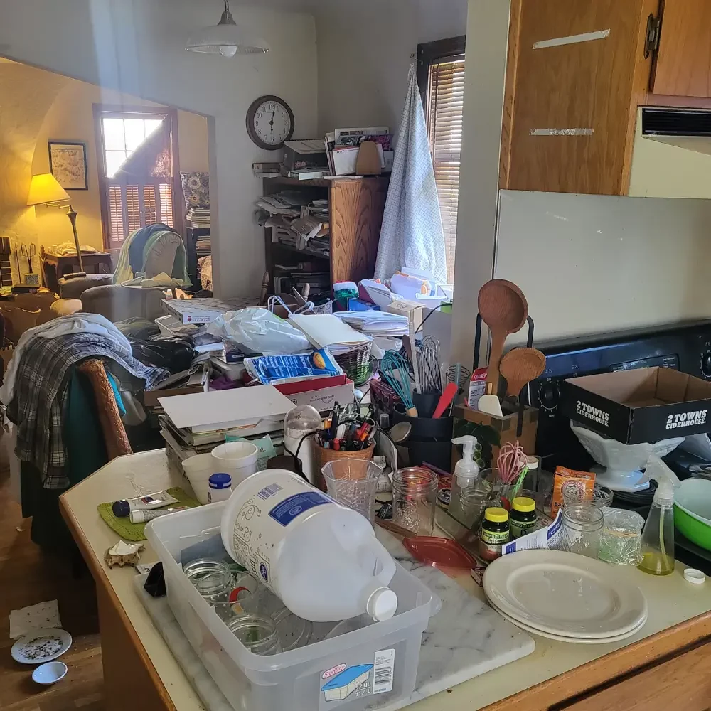 Cluttered kitchen full of broken home goods before cleanout